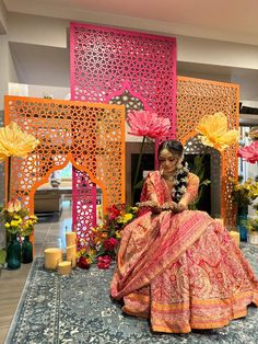 a woman sitting on the ground in front of an elaborately decorated wall and floor