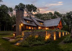 a stone and wood house with lights on