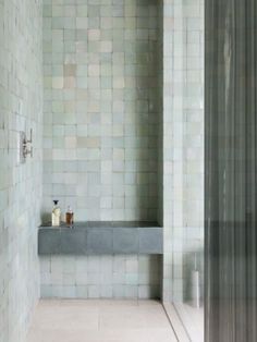 a bath room with a sink and a shower head mounted to the side of a wall