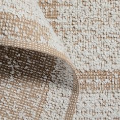 a close up view of the texture of a rug with white and brown colors on it