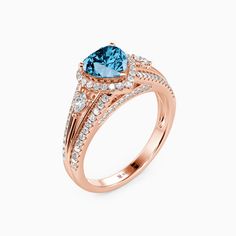 a rose gold ring with a blue topazte and white diamonds on the sides