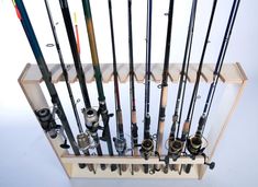 there are many different fishing rods in the holder on this shelf, and one is empty