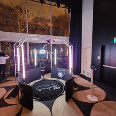 the stage set up for an event with black and white carpeted flooring, round seating