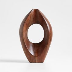 a wooden sculpture sitting on top of a white surface