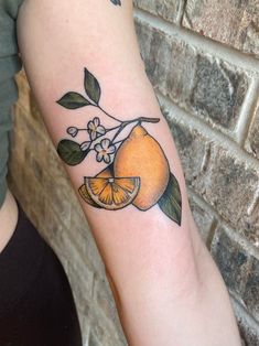 an orange with leaves and flowers on the arm