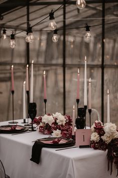 the table is set with candles, flowers and napkins for an elegant wedding reception