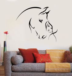 a living room with a couch and a horse wall decal