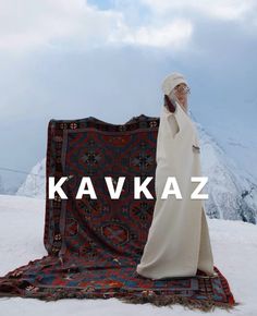 a man standing on top of a snow covered ground next to a blanket with the words kavkaz