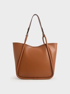 Your quintessential everyday bag gets a sophisticated flair. Classic, casual, and chic, this extra-large tote bag is made in a stunning cognac hue that effortlessly exudes a polished appeal, suitable for all seasons. Topped with a circle handle that is easy to sling over your shoulder, it also comes with a detachable inner pouch for added storage. With such elegance and simplicity, this stylish number will undeniably earn a prime spot in your collection. Don it out with a belted vest dress and Slouchy Tote Bag, Extra Large Tote Bags, Circle Handle, Slouchy Tote, Oversized Tote Bag, Oversized Tote, Charles Keith, Everyday Bag