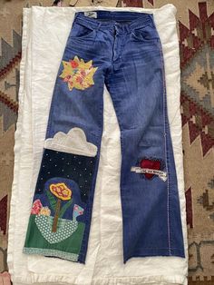 a pair of blue jeans with patches on them