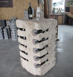 a wine rack made out of rocks with bottles on it