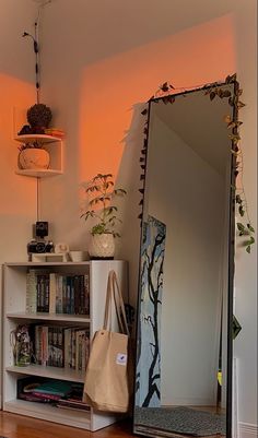 a mirror sitting on top of a wooden floor next to a book shelf