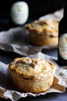 two muffins sitting next to a bottle of beer