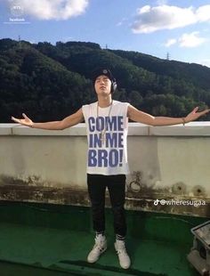 a man standing on top of a boat with his arms spread out in front of him