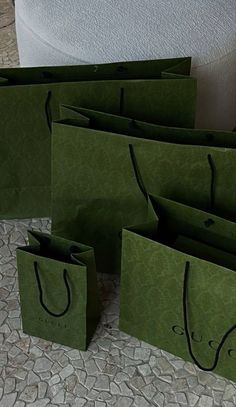 several green bags sitting on the ground next to each other