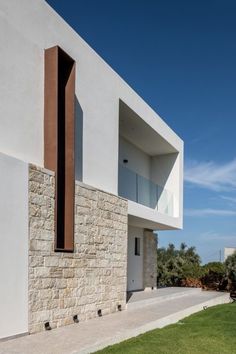 an exterior view of a modern house with stone and wood accents on the outside wall