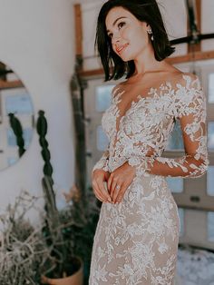 a woman in a white dress posing for the camera with her hands on her hips