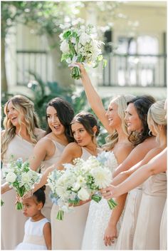 a group of women standing next to each other holding bouquets