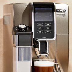 an espresso machine with a cup of coffee next to it