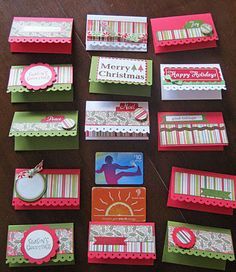 many cards and tags are arranged on a wooden table with the words merry christmas written across them