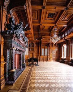 an ornate room with wood paneling and chandeliers on either side of the fireplace