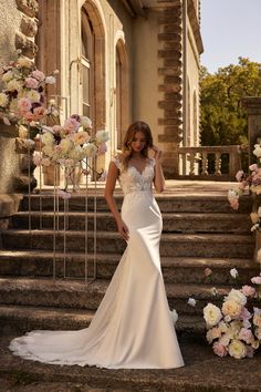 a woman in a wedding dress standing on some steps