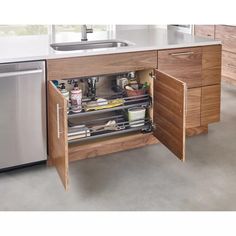 an open cabinet in the middle of a kitchen with stainless steel sink and dishwasher