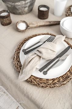 a table set with plates, silverware and napkins