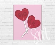 two heart shaped lollipops with the word big and small on them against a brick wall