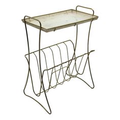 a metal and glass table with two magazine racks