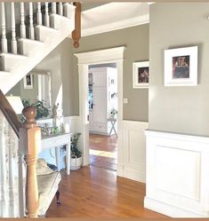 an entry way with stairs and pictures on the wall