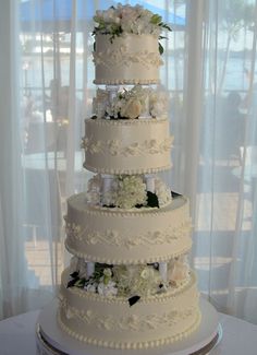 a three tiered wedding cake with white flowers