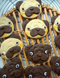 some cookies with googly eyes and mustaches are on a cooling rack for display