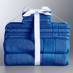 a stack of blue towels tied up with a white ribbon and bow on the top