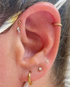 a close up of a person with ear piercings on their ears and behind the ear