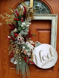 a christmas wreath on the front door of a house with nol painted on it