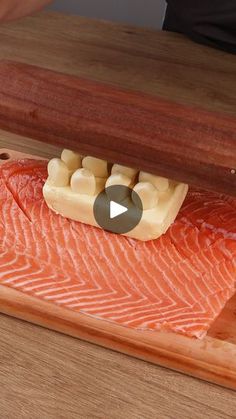 a piece of salmon on a wooden cutting board