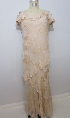 a dress on a mannequin with an off the shoulder top and ruffled skirt