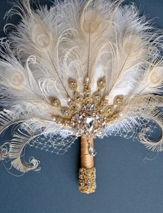 a white and gold feather corsage on a blue background with feathers attached to it