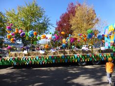 a parade float decorated with balloons and streamers