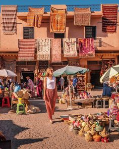 a woman is walking through an outdoor market