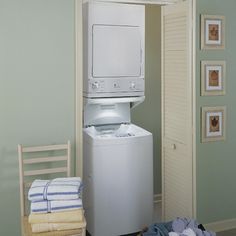 a washer and dryer sitting in a room next to a wall with pictures on it