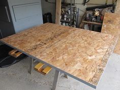 an unfinished table in a garage with tools on the floor