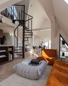 a living room with a spiral staircase in the center and an orange bean bag on the floor