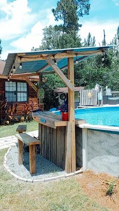 an outdoor bar next to a pool with a grill on the side and a picnic table under it