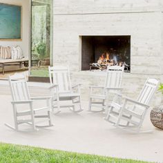 four white rocking chairs sitting in front of a fire place with a fireplace behind them