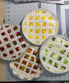 four quilted pies are displayed on a cutting board