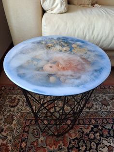 a blue table sitting on top of a rug next to a couch