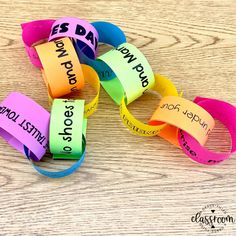 colorful bracelets with words written on them sitting on a wooden table next to each other