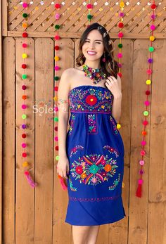 This Beautiful Strapless Dress boasts a Traditional Mexican floral design combined with a modern style dress. It's made out of fine Mexican cotton and has elastic on the back for a tighter fit. It has hand embroidered flowers and hand knit details throughout. This dress is handmade by Mexican Artisans in Mexico. Note: Since this dress is Hand embroidered the embroidered colors on each dress vary, making them one of a kind. Purchase the handmade artisanal necklace modeled here: https://www.etsy.c Mexican Fiesta Party Outfit Women, Mexican Fiesta Party Outfit, Traditional Floral Embroidered Dress For Cinco De Mayo, Traditional Embroidered Dress For Fiesta, Mexican Party Dress, Mexican Bridesmaid Dresses, Folk Style Fiesta Dress With Floral Embroidery, Mexican Clothes, Bridgerton Ball